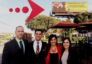 The ICSC team poses in front of their billboard.