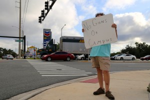 Speaking out against the guns on campus bill, Dexter Rambo holds a sign that reads "No Guns On Campus" at the intersection of University and Alafaya.