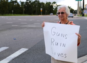 Lorraine Tuliano, a UCF engineering graduate, protesting the guns on campus bill by holding a "Guns Ruin Lives" sign at the Alafaya and University intersection. Some approving drivers honked their horns as they passed. Photo by Katrina Poggio