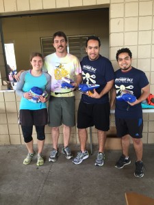 The Random Meta ChGs, the winning team of the 13th annual Adventure Race, pose at Lake Claire's pavilion with their prize packages in hand. Left to right: Laura Sisken, Colin Constant, Abraham Vazquez, and Rafael Guzman. Photo credit: Lauren Pierce